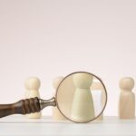 A figure is singled out for viewing with a magnifying glass