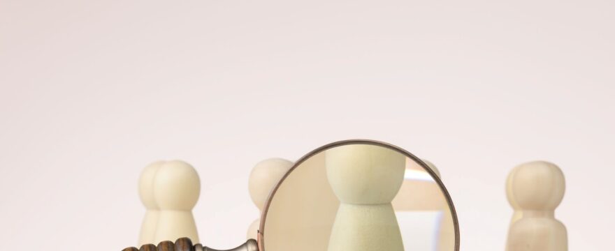 A figure is singled out for viewing with a magnifying glass