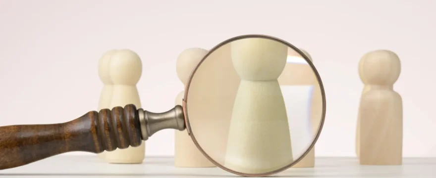 A figure is singled out for viewing with a magnifying glass